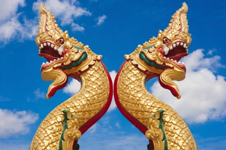 golden naga in thai temple with blue sky backgroundの写真素材