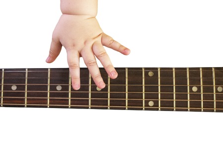 Close up photo child hand playing acoustic guitar. Guitar neck and playing the strings hand of a...