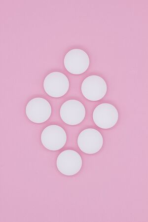 vitamins, pills and tablets. White capsules against a pink background