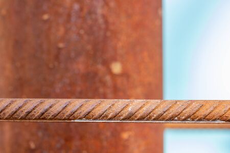 macro of corrosion-textured vintage rusty metal pole, rusty metal fence close-up sunlit.の写真素材