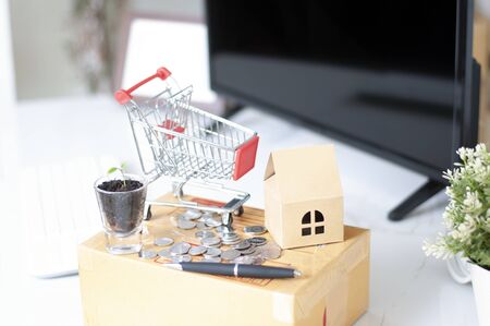 shopping online concept :Shopping Cart onthe box with paper home mock up. Shooping online delivery at home.Work desk blur background.Copyspace for text. nobody.Online Delivery. の写真素材