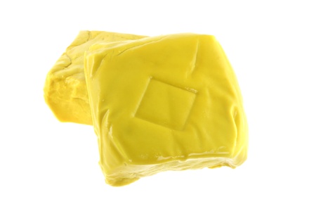 Closeup photography of Fresh Firm Yellow Chinese Tofu coated with turmeric, isolated on white