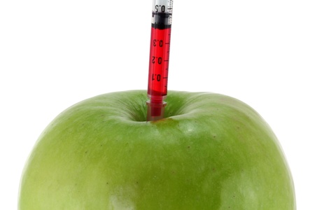 Conceptual photo of Genetic Modification - Red Liquid injecting to a Green Appleの写真素材