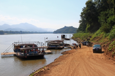 Luang Prabang, Laos - 29 December 2012   People using local ferry to transport vehicles cross the Mekong River in Luang Prabang, Laosのeditorial素材