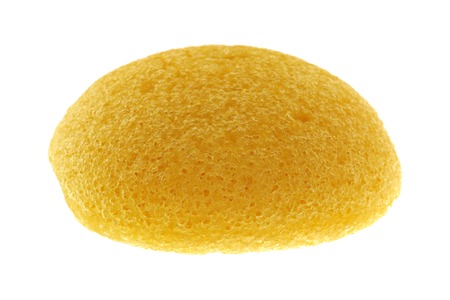 A round yellow natural facial Sponge made of vegetable fiber, Konjac, isolated on whiteの写真素材