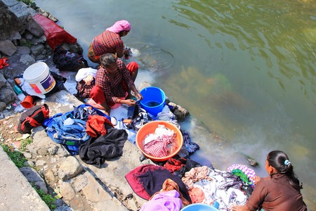 Nepalese women washing clothes along the river in Pokhara city, Nepal.のeditorial素材