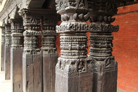 PATAN, NEPAL - APRIL 2014 : Beautifully carved wooden pillars at Patan Museum in Patan, Nepal on 13 April 2014. Patan Museum is an old residential court of Patan Darbar, one of the royal palaces of the former Malla kings of the Kathmandu Valley.のeditorial素材