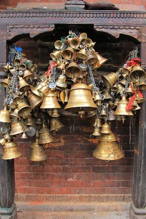 Metal sacrificial bells hanging on chain at Kumbeshwar Temple in Patan, Nepal. Bell is one of the worship materials to Hindu Goddess.のeditorial素材