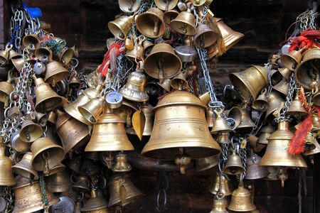 Metal sacrificial bells hanging on chain at Kumbeshwar Temple in Patan, Nepal. Bell is one of the worship materials to Hindu Goddess.のeditorial素材