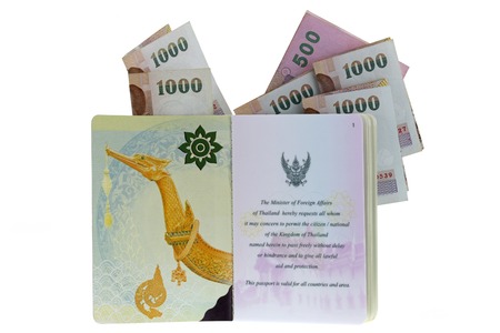 Thai electronic passport (issued by a government in Thailand), with folded 500 and 1000 Baht Banknotes, isolated on white backgroundの写真素材