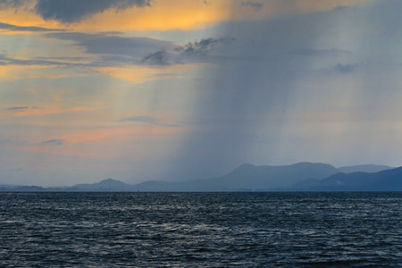 Evening view of the sky with bad weather with severe rainstorm from afar over the sea