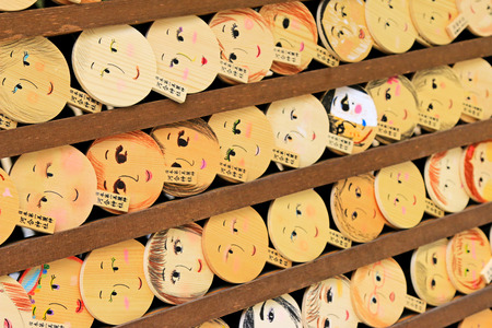 Shallow depth of field of mirror-shaped wooden preyer tablet Kagami ema in Kyoto, Japan. Its believed to paint the face, make a wish and your face will become more beautifulのeditorial素材