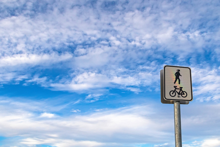 Shared bicycle riding lane and pedestrian path on a pole post against blue sky with clouds in Robe, South Australia. Photo with copyspaceの写真素材