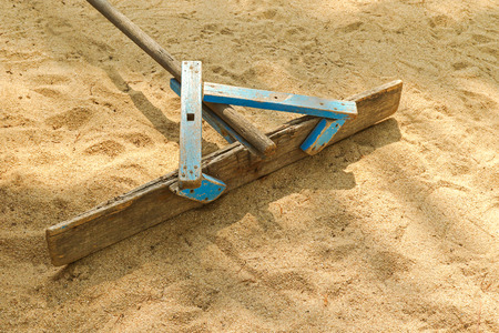 Handmade wooden stick to flatten, level and smooth surface of sand on the beach の写真素材