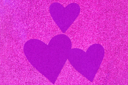 Glittery texture of glitter in magenta with blurred purple violet heart. Abstract background photoの写真素材