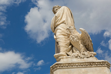 Low angle view of eagle and statue of Durante degli Alighieri, also called Dante in the Piazza di Santa Croce in Florence, Italy. Dante is Italian poet of the late Middle Agesの写真素材