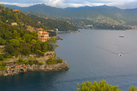 Windy wavy road along Portofino cove, street cut into cliff at Portofino port, Italian fishing village, Genoa province, Italyの写真素材