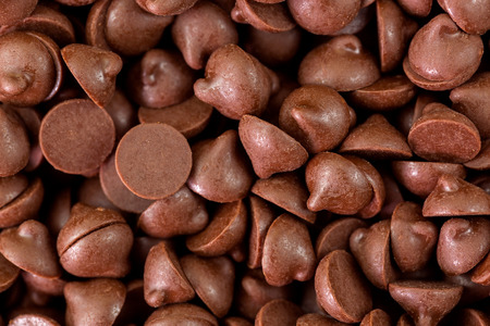 Closeup texture macro of small chunks of sweetened chocolate chips backgroundの写真素材