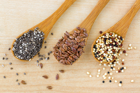 Dried Chia seed, Linseed flaxseed, Quinoa seed tri-color blend on wooden spoon, wood backgroundの写真素材