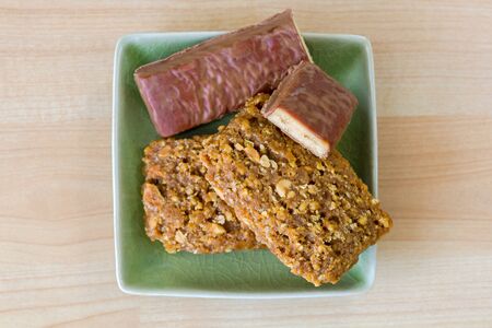 Crunchy peanut butter Energy bar with protein, coconut chocolate flavor, minerals in green plateの写真素材