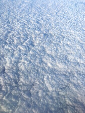 View of white clouds through airplane window, hovering above Black seaの写真素材
