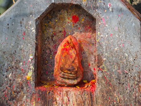 Shrine covered in vermillion to worship Goddess Kali. Red pigment powder on stone, part of Kali Shrine on the mountain in Dhulikhe, Nepalの写真素材