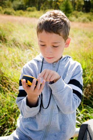 young boy looking at gps while geocachingの写真素材