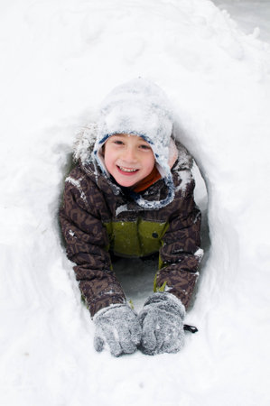 young boy playing outdoors on a snowy winter dayの写真素材