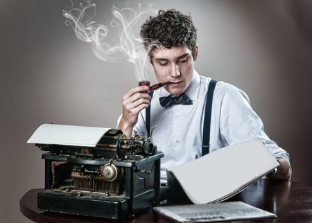 journalist with a vintage typewritter,bowtie, and pipeの写真素材