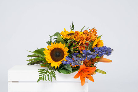 beautiful bouquet of fall flowers on a white crateの写真素材