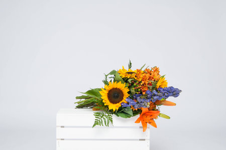 beautiful bouquet of fall flowers on a white crateの写真素材