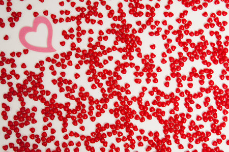 single felt heart with cinnamon heart candies on a rough textured painters canvas background