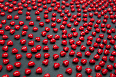 Red cinnimon candy hearts for valentine's day on a dark background