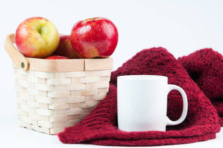 coffee mug mockup with basket of red apples and blanket on a white backgroundの写真素材