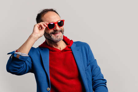 Stylish senior man peeking through sunglassesの写真素材