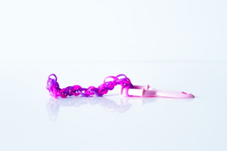 Rainbow loom- Colored rubber bands for weaving accessories on a white backgroundの写真素材