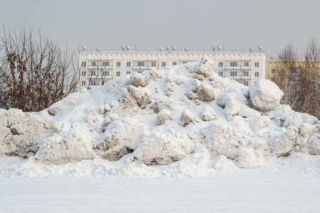 Big mountain snow near the road in the city