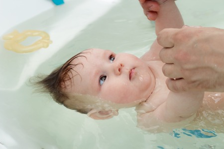 Newborn baby bathe and swim in a large tub