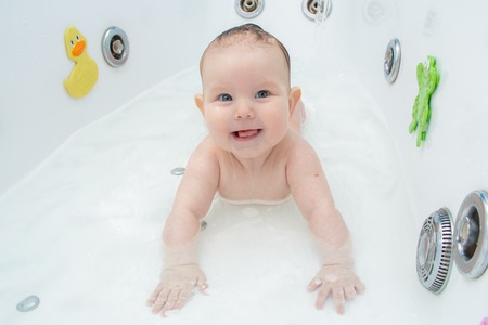 Newborn baby bathe and swim in a large tubの写真素材