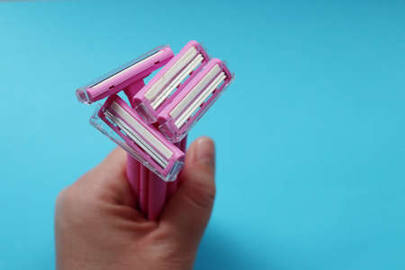 Womens disposable pink shaving razor in hand