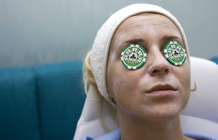 Poker chips lying on eyes like cucumbers in spa salon Poker chips lying on eyes like cucumbers in spa salon