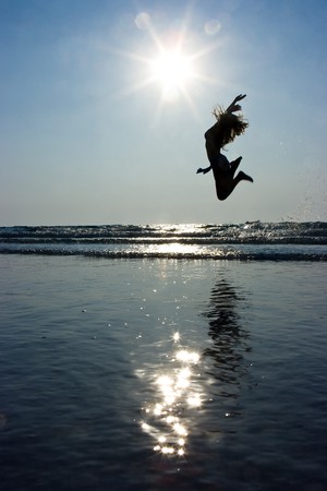 Girl in high jump over the seaの写真素材