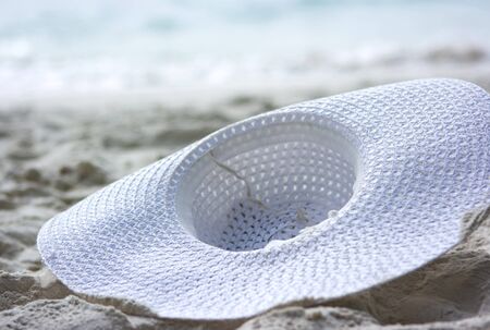 White hat lies on the beach sandの写真素材