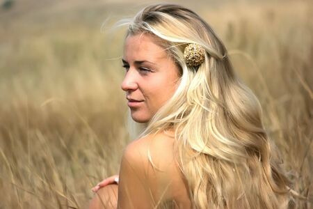 Beautiful girl with blond hair in the fieldの写真素材