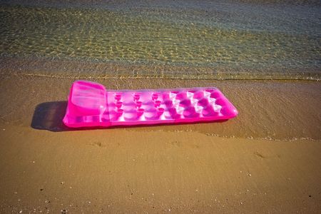 Pink inflatable raft on the sand sea beachの写真素材