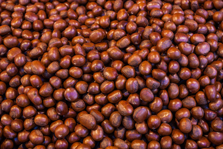 Pile of roasted chestnut for retail sale in market.の写真素材