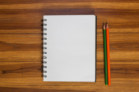 Notebook and pencil on the wooden floor.