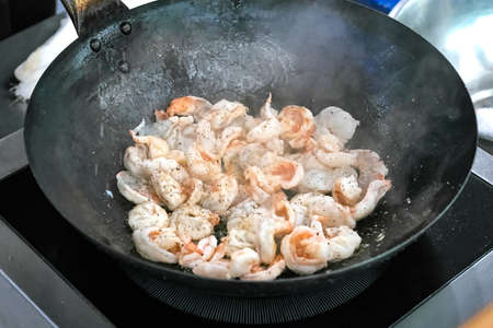 fried shrimp in avocado oil in a frying panの写真素材