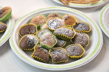 Small cupcakes in paper baskets sprinkled with sweet powderの写真素材