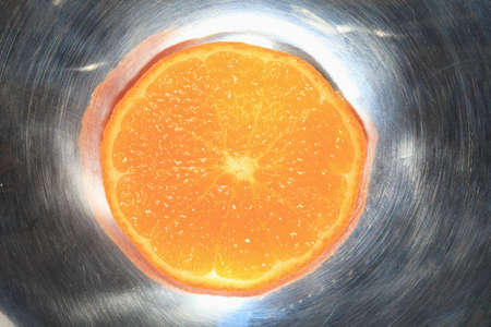 Slice of Mature Mandarin orange closeup on a dark background.